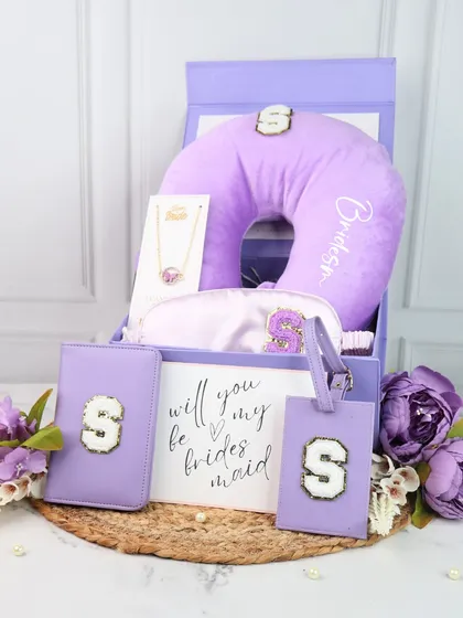 Our signature bridesmaid travel hamper in a lovely lilac. This set includes a personalized neck pillow, eye mask, passport cover, and luggage tag, all featuring the same initial patch for a coordinated look.