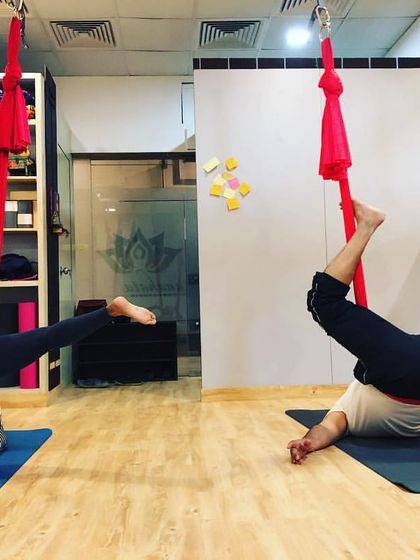 Students in an aerial back straddle. This pose requires core strength and control, and is a great way to build confidence with inversions.