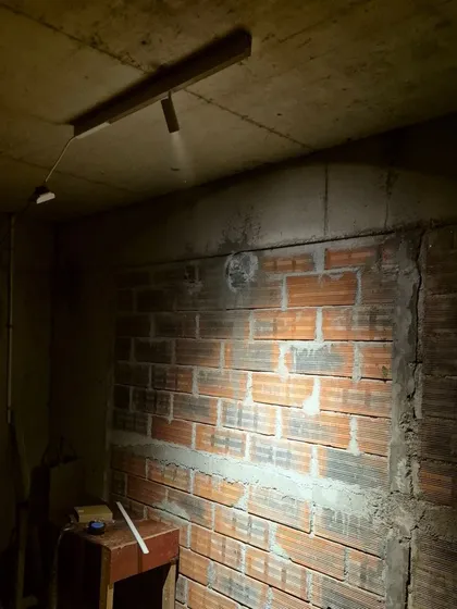 An on-site mock-up in a raw construction space. We use these tests to check the beam angle and intensity of our track lights against the actual surfaces, like this exposed brick wall, ensuring the final effect is exactly as planned.
