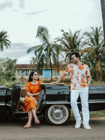 A stylish couple poses with a vintage Chevrolet convertible on a palm-lined road in Goa. This shot combines travel, style, and romance, perfect for a cinematic pre-wedding story with a cool, retro vibe.