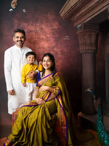 A complete family portrait that feels both grand and intimate. The traditional attire, artistic backdrop, and peacock details all contribute to a stunning fine art photograph.