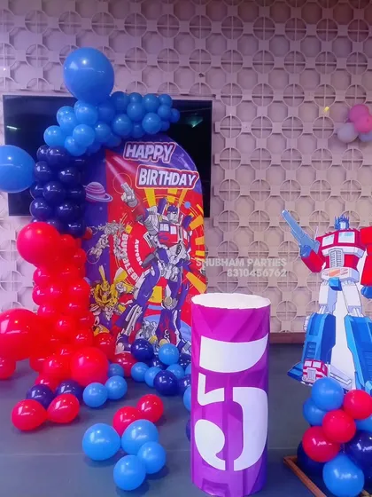 An exciting Transformers themed party with an Optimus Prime cutout and a red and blue balloon setup.