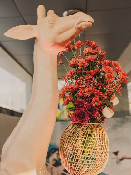 A close-up of the giraffe holding a custom-made basket of flowers, a whimsical detail that guests loved.