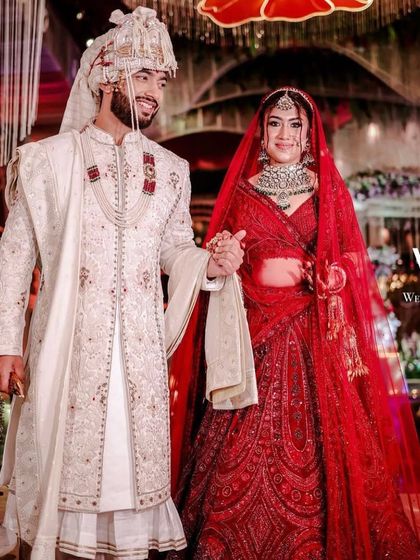 A picture-perfect moment. This bride in her stunning red lehenga chose a heavy polki and emerald set to complete her dreamy wedding look.
