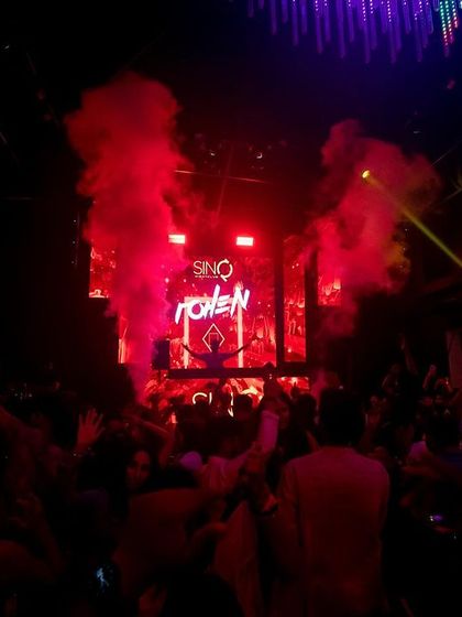 The iconic 'ROHEN' logo on the screen at SinQ, Goa, with red smoke creating a powerful visual.