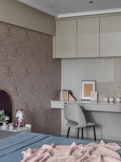 This bedroom uses beige as a base color, with pops of purple and pink to add charm. The streamlined study desk and overhead storage make it a cozy and functional space.