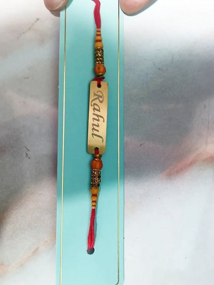 A closer look at the craftsmanship of the personalized metal name Rakhi.