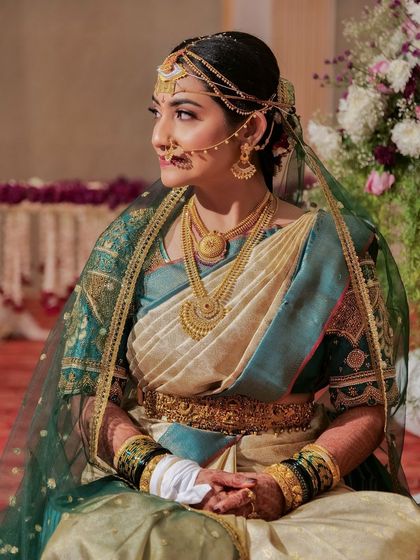 A regal bridal portrait. The bride is wearing a traditional nose ring and headpiece, and her makeup is kept classic and elegant to match the grandeur of her attire.