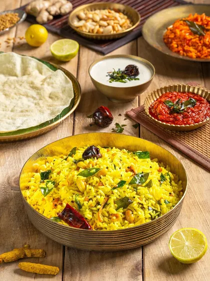 A bowl of tangy Lemon Rice, a staple in South Indian cuisine. The bright yellow color and fresh ingredients make it look very refreshing.
