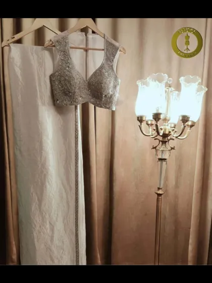 A classic combination of an all-white saree with a heavily embellished silver blouse. A timeless choice for any elegant affair.