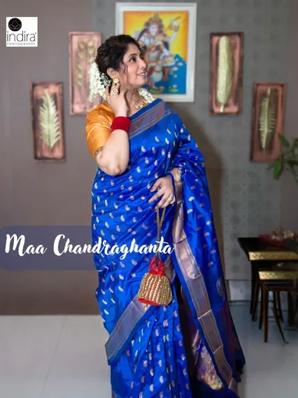 A stunning royal blue saree for Maa Chandraghanta on Day 3 of our Navratri series. This full-length portrait showcases the saree's drape and the traditional accessories, set against a decorated wall to add a touch of home and context.