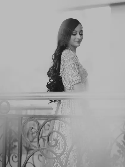 An artistic black and white photo of the bride, using a soft focus and foreground elements to create a dreamy, ethereal quality.