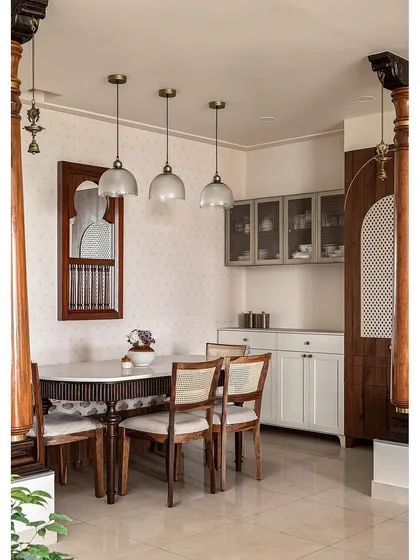 To honor the client's cultural heritage, I designed this dining area with traditional elements like carved wooden columns and a 'katte' bench seat. The dining table features classic leg details, paired with simple cane chairs. A small window mirror on the wall adds depth, reflecting the traditional swing and creating a space rich with history and warmth.