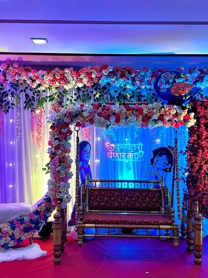 Here is another view of my popular moon and jhula combination for a baby shower. The dramatic pink and blue lighting enhances the floral arrangements and creates a festive atmosphere for the gender reveal.