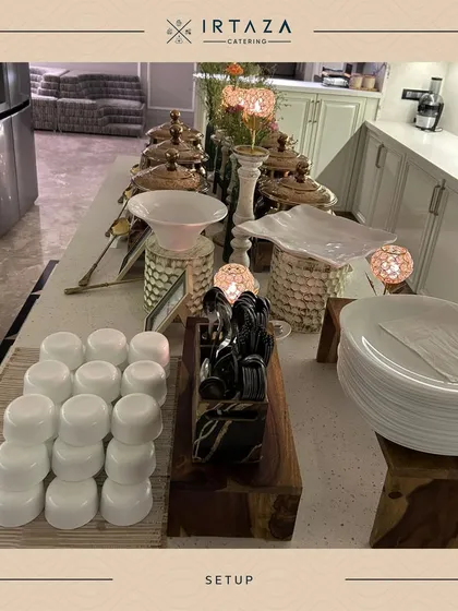 A clean and professional setup for a home catering event. The use of wooden risers and white serveware on a kitchen island shows how I can transform a home space into an elegant serving area.
