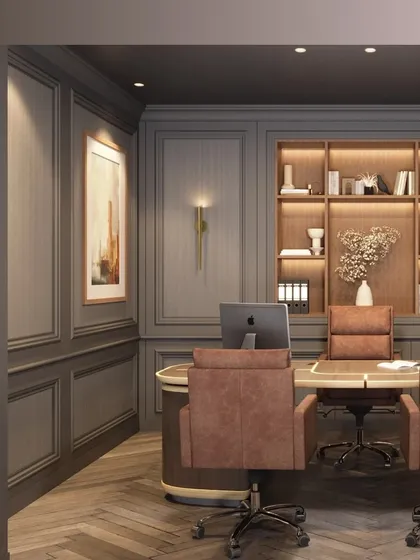 A view of a modern executive office with soft neutral tones and salmon-colored chairs. The design features herringbone wood floors and custom built-in shelving with accent lighting, creating a space that is both luxurious and highly organized.