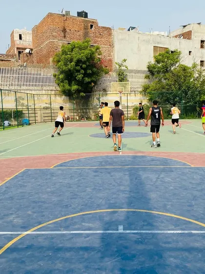A wide view of a full-court game in progress. Players are transitioning from defense to offense, a critical part of the game's flow.
