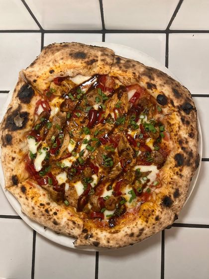 A top-down view of the Adobo Chicken pizza. You can see the delicious swirls of sauce and scattered scallions.