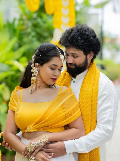 An intimate portrait of a couple. Her modern yellow top and draped skirt are complemented by his classic white kurta and yellow stole, showcasing our versatile design capabilities.