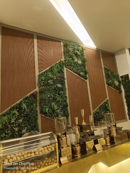 Another view of the geometric green and wood wall, showing how it complements the brass and gold tones of the food dispensers.