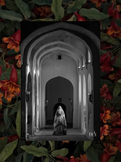 A dramatic black and white shot of a bride standing in a long, arched hallway, creating a sense of mystery and elegance.