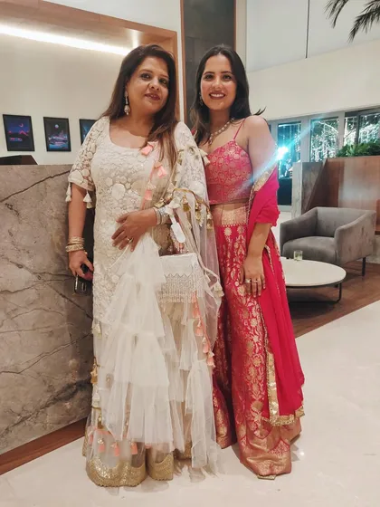 Posing with my mom at a wedding. My red Benarasi suit complemented her elegant white and gold outfit perfectly.