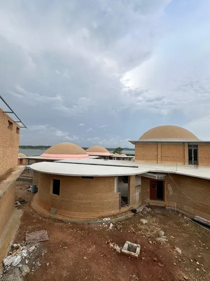 A view of the clay-built resort project, showcasing the unique dome architecture. Our landscape design will complement these organic forms, using natural materials to create harmony between the buildings and the land.