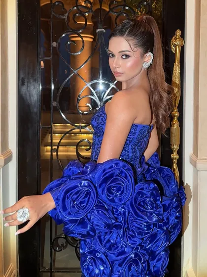 A bold and dramatic look in a royal blue gown with large rosette details on the sleeves.