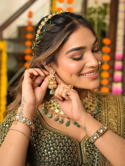 A happy, candid moment. The bride's smile is infectious, and her glowing makeup enhances her joy, making her look absolutely radiant for her festive event.