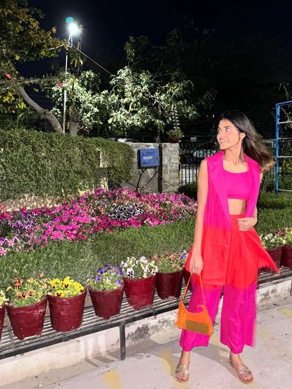 A candid shot of the Holi outfit in motion. The bright pink and orange are perfect for the festive and joyful atmosphere of the holiday.