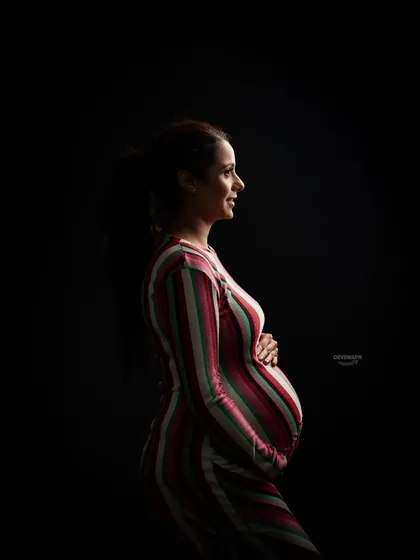A beautiful profile silhouette, this time in color. The single light source illuminates the client's form in a striped dress, creating a striking contrast against the pure black background.