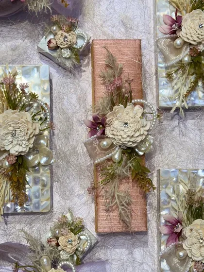 A top-down view of the individually wrapped gifts inside the acrylic box, showcasing the variety of textures and embellishments used.
