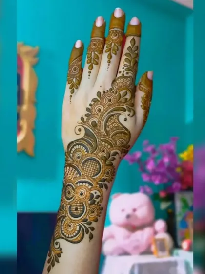 This graceful Arabic mehendi design flows from the wrist to the index finger. The combination of delicate leaves and bold, shaded patterns creates a very elegant look.