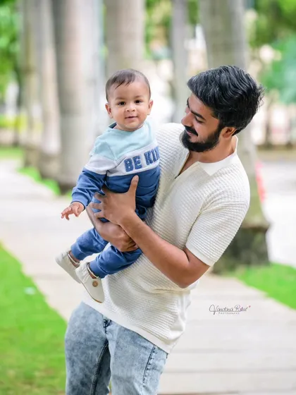 A father holds his baby boy during a walk in the park. I specialize in outdoor toddler shoots in Bangalore, capturing your little one's explorations.
