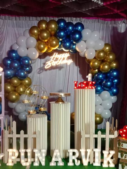 Here is another angle of Punarvik's first birthday party decor, showing the blue, gold, and white balloon arrangement. I can customize the color palette to perfectly match your party's theme.
