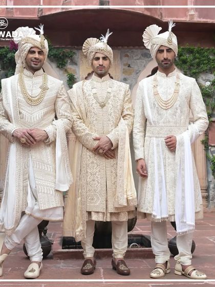 Three grooms stand together, presenting a united front of royal style. The variations in their sherwanis highlight the depth and versatility of the Shauhar collection.