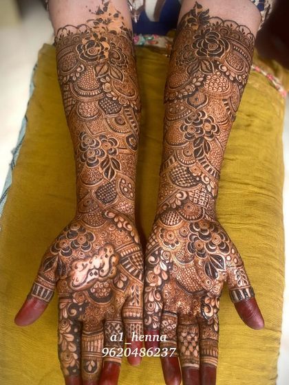 This design showcases a beautiful blend of floral patterns and leafy vines, covering the hands and arms in a rich tapestry of henna.