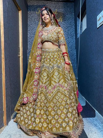 A full view of the heavy golden-green bridal lehenga. This outfit is perfect for a bride who wants a royal and opulent look for her wedding.