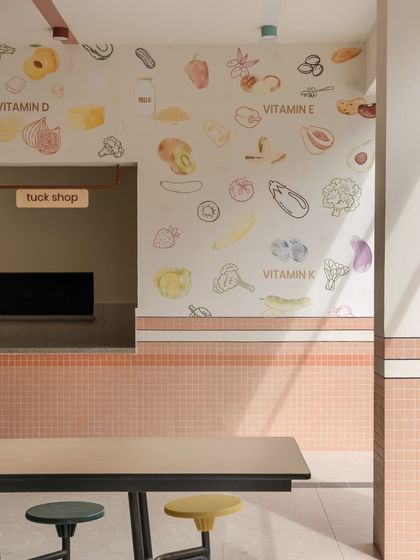 A close-up of the "tuck shop" area, where wall graphics illustrate different vitamins and the foods they can be found in. This simple visual guide makes nutrition science accessible and fun for kids.