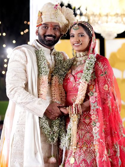 A classic wedding portrait of the couple smiling for the camera. This shot is essential for capturing the formal record of the day, showcasing their beautiful wedding attire.
