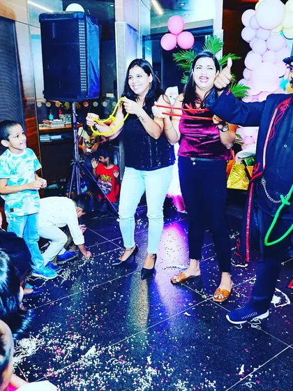 A thumbs up for a successful trick. The volunteers and the audience are all enjoying the interactive magic at this birthday party.