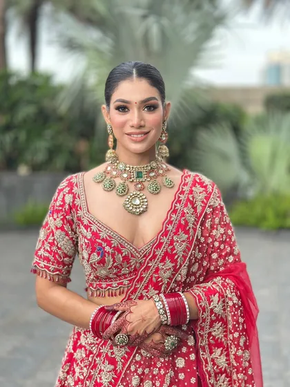 A closer portrait of this stunning bride. You can see the clean, radiant makeup and the sleek, pulled-back hair that perfectly complements her deep V-neck blouse and statement necklace.