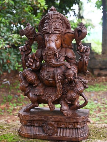 A full-view of the Lambodara Ganapathy in an outdoor setting, highlighting the rich texture of the wax brown finish.