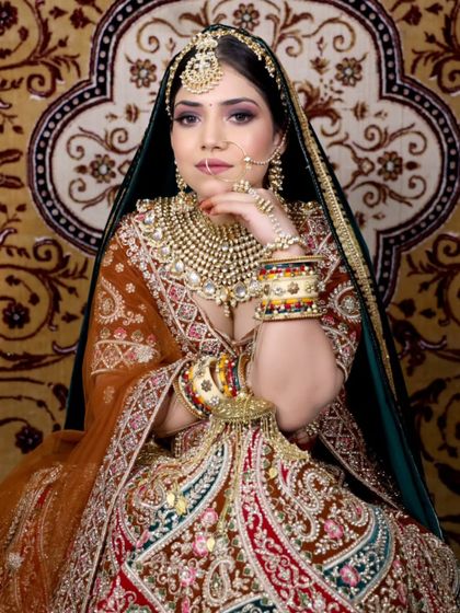 A grand, multi-colored lehenga is paired with an equally grand Kundan jewellery set. The intricate bangles and hathphool complete this maximalist bridal look.