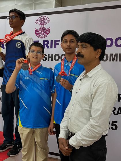 Young medalists on the podium with their coach after a successful competition.