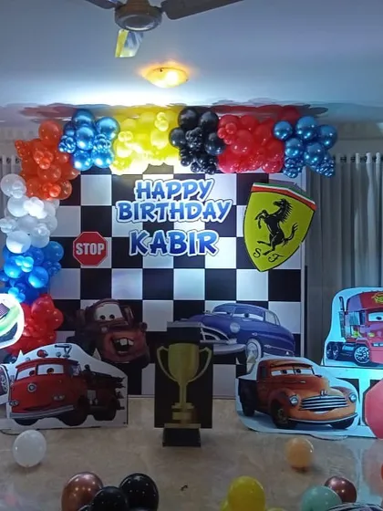 A high-octane Disney Cars theme with a checkered flag backdrop, character cutouts of Lightning McQueen and Mater, and a Ferrari logo for the birthday boy.