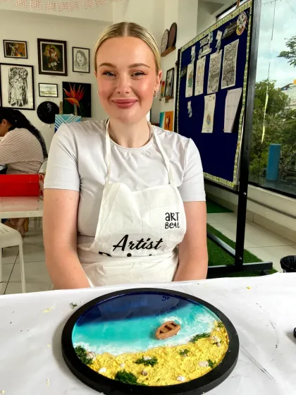 A participant fully focused on her resin beach art creation. The process is meditative and allows you to bring your own unique coastal vision to life.