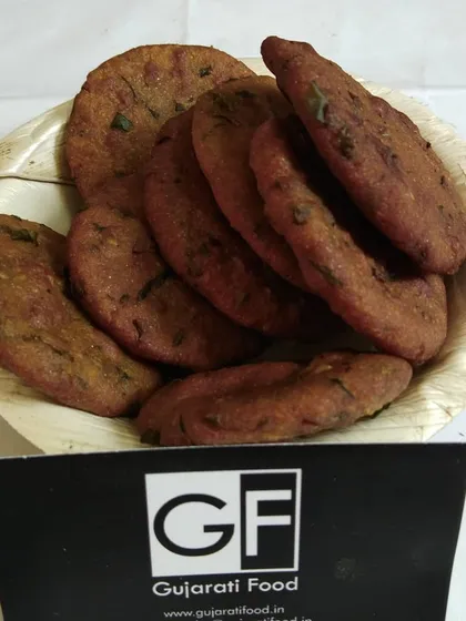 A bowl of my homemade Bajra Vada. These are deep-fried fritters made from pearl millet flour and spices, offering a unique texture and taste that is both crispy and savory.
