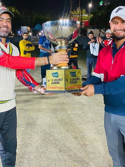 The captains of the two finalist teams with the championship trophy, showcasing sportsmanship after a competitive final.