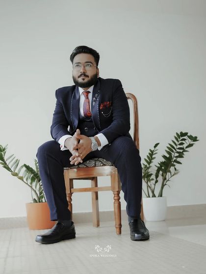 A portrait of the groom, looking distinguished and ready for the big day in his navy blue three-piece suit.